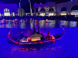 Boat with actors in front of the Chimera Fountain at the Shopping Avenue area of the Land of Legends theme park, during the Musical Boat Parade, by night