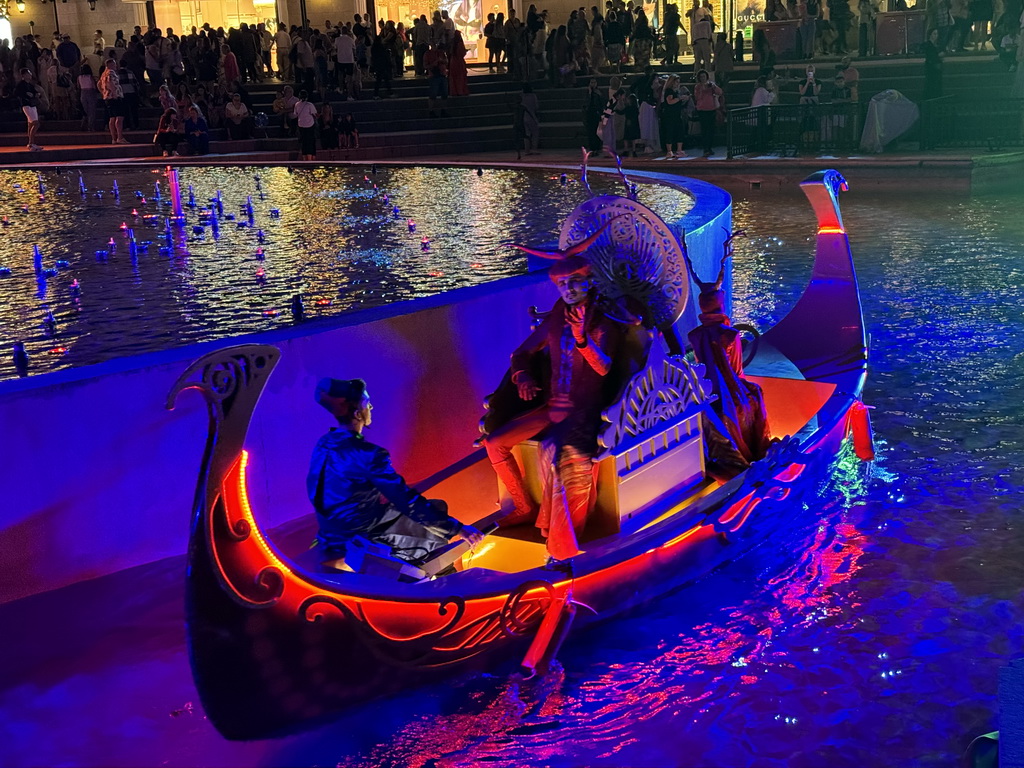 Boat with actors in front of the Chimera Fountain at the Shopping Avenue area of the Land of Legends theme park, during the Musical Boat Parade, by night