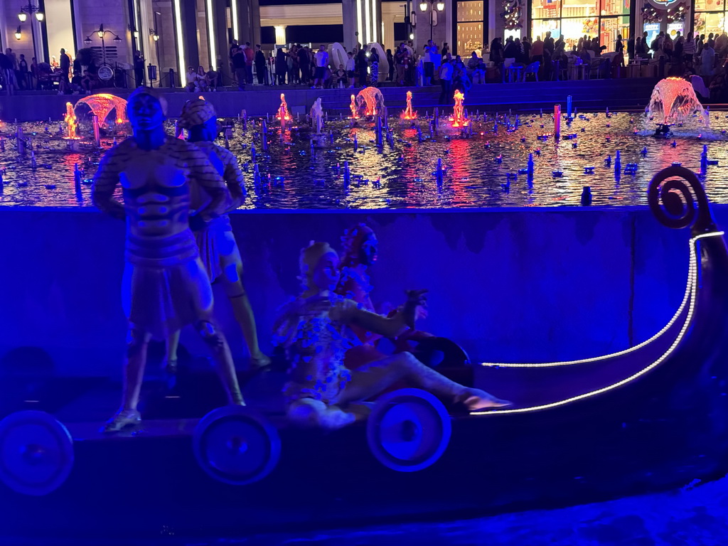 Boat with actors in front of the Chimera Fountain at the Shopping Avenue area of the Land of Legends theme park, during the Musical Boat Parade, by night