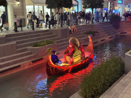 Boat with actors at the canal at the Shopping Avenue area of the Land of Legends theme park, during the Musical Boat Parade, by night