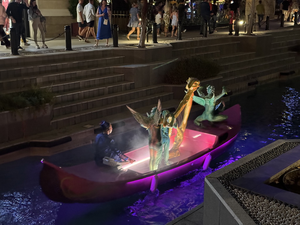 Boat with actors at the canal at the Shopping Avenue area of the Land of Legends theme park, during the Musical Boat Parade, by night