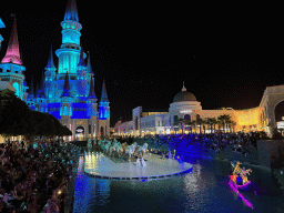 Boats, actors and horse statues in front of the Chateau at the Shopping Avenue area of the Land of Legends theme park, during the Musical Boat Parade, by night