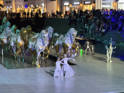 Actors and horse statues in front of the Chateau at the Shopping Avenue area of the Land of Legends theme park, during the Musical Boat Parade, by night