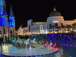 Boats, actors and horse statues in front of the Chateau at the Shopping Avenue area of the Land of Legends theme park, during the Musical Boat Parade, by night