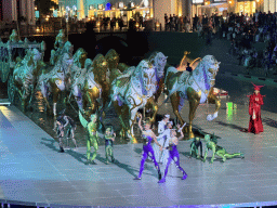 Actors and horse statues in front of the Chateau at the Shopping Avenue area of the Land of Legends theme park, during the Musical Boat Parade, by night