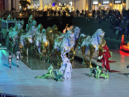 Actors and horse statues in front of the Chateau at the Shopping Avenue area of the Land of Legends theme park, during the Musical Boat Parade, by night