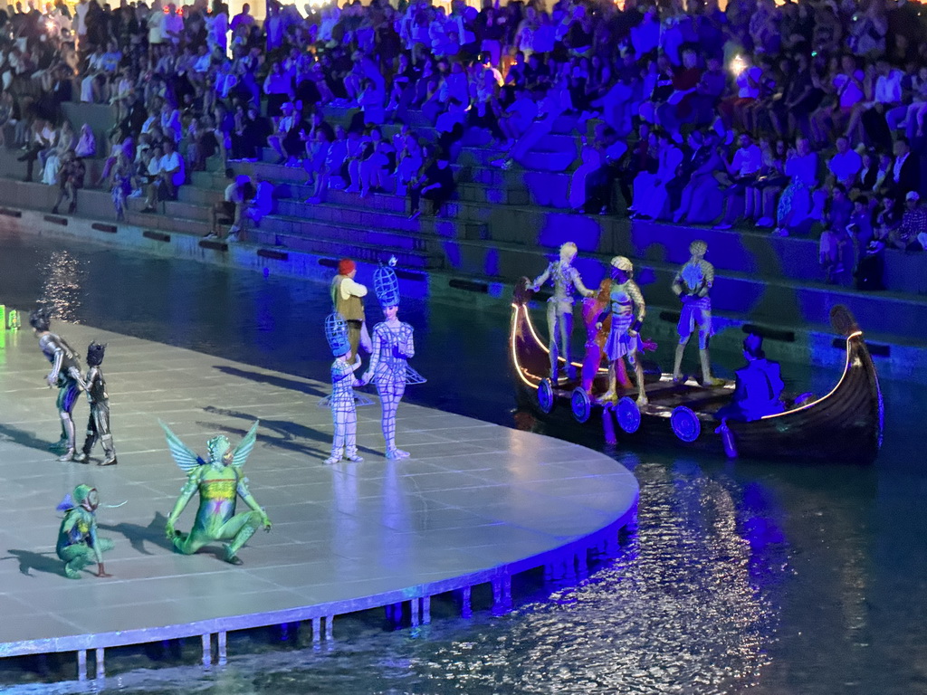 Boats and actors in front of the Chateau at the Shopping Avenue area of the Land of Legends theme park, during the Musical Boat Parade, by night