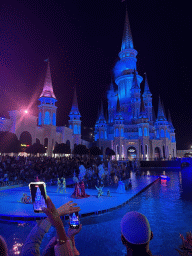 Boats, actors and horse statues in front of the Chateau at the Shopping Avenue area of the Land of Legends theme park, during the Musical Boat Parade, by night