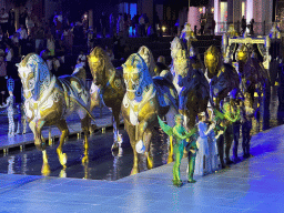 Actors and horse statues in front of the Chateau at the Shopping Avenue area of the Land of Legends theme park, during the Musical Boat Parade, by night