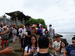 Tourists making photos of the Pura Tanah Lot temple from the shore at the Pura Luhur Penataran temple