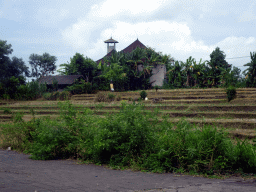 Building, tower and rice fields along the Jalan By Pass Tanah Lot road, viewed from the taxi