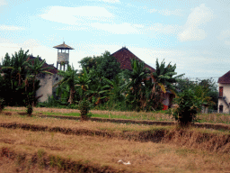 Building, tower and rice fields along the Jalan By Pass Tanah Lot road, viewed from the taxi