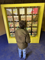 Max with a puzzle game at the room of the youngest son at the Ghana village at the Museumpark of the Africa Museum