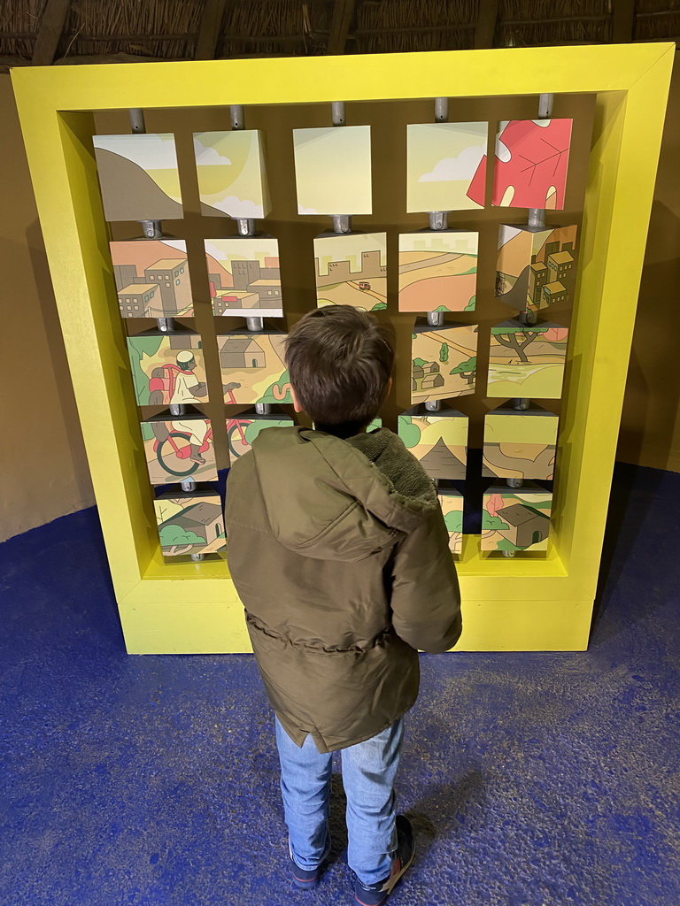 Max with a puzzle game at the room of the youngest son at the Ghana village at the Museumpark of the Africa Museum