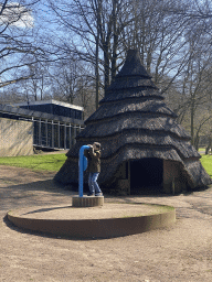 Max with a speaking tube in front of a house at the main square of the Museumpark of the Africa Museum