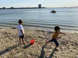 Max and his friend at the beach at the Binnenschelde lake, with a view on the Mayflower Holding building