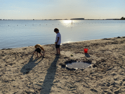 Max and his friend playing with sand at the beach at the Binnenschelde lake