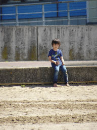 Max holding a rock at the beach at the Binnenschelde lake