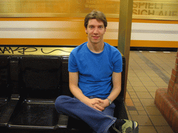 Tim on a bench at a subway station