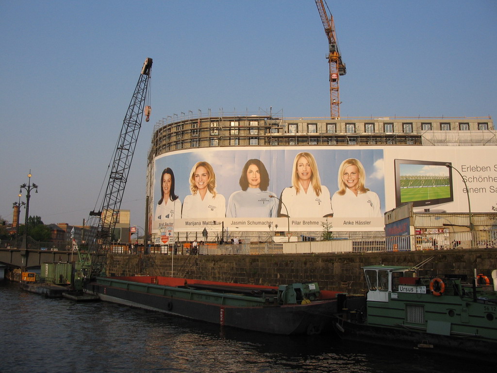 Boats on the Spree river and the Meliá Berlin hotel at the Friedrichstraße street, under construction, viewed from the tour boat