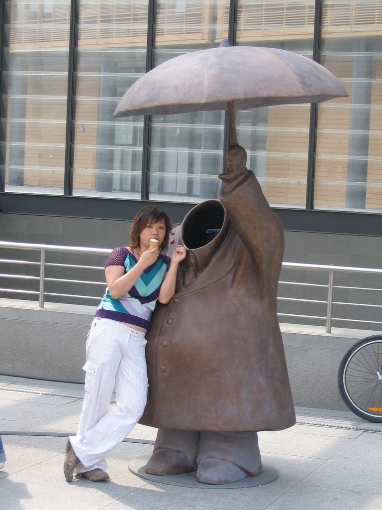 Miaomiao with an ice cream and a statue at the Potsdamer Platz square