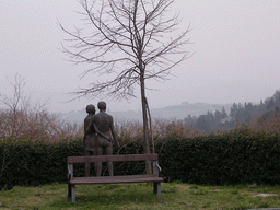 Statue and bench at the southwest side of the La Rocca castle, with a view on the hills around the town