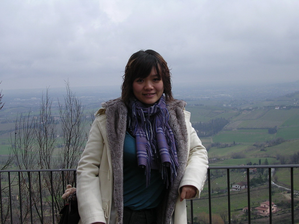 Miaomiao at the parking lot of the La Rocca castle, with a view on the hills at the west side of the town