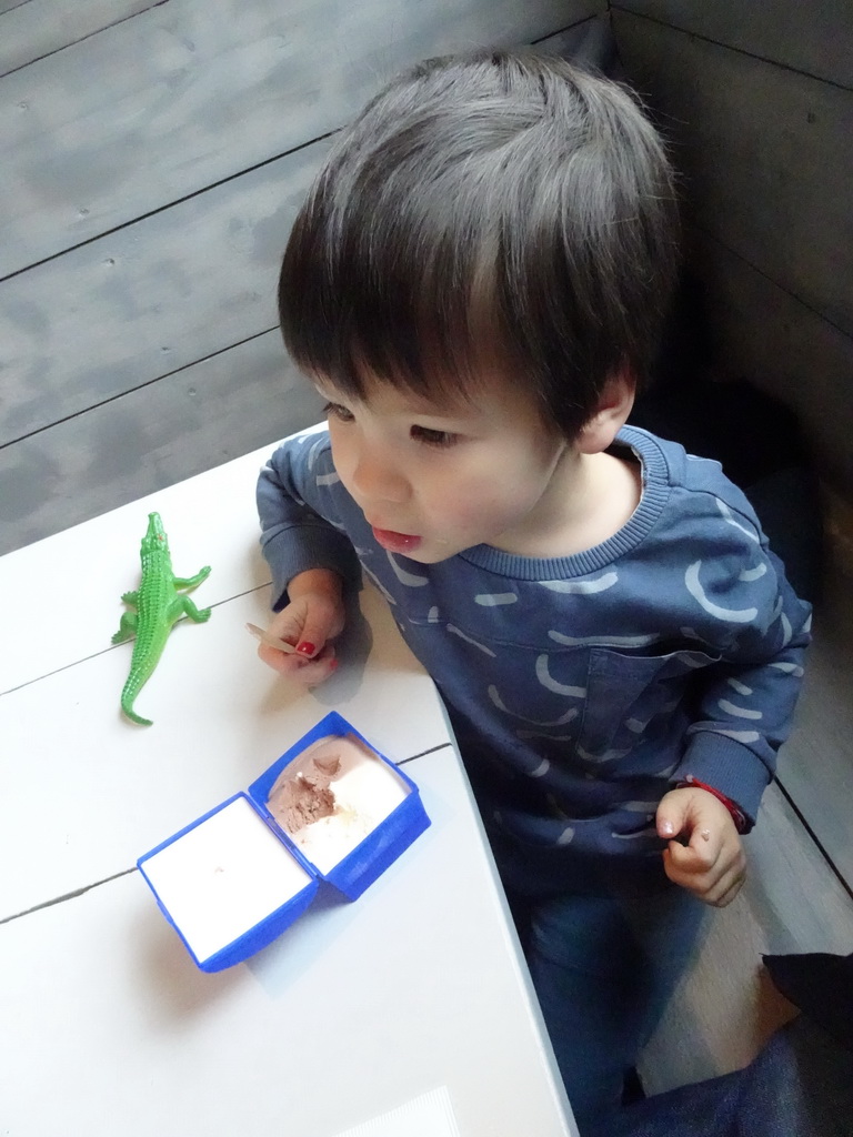 Max with a crocodile toy and an ice cream at the restaurant at BestZoo