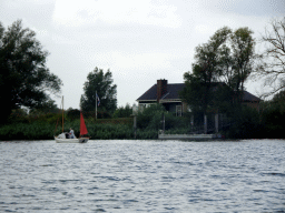 Boat on the Gat van den Kleinen Hil lake and a house, viewed from the Fluistertocht tour boat