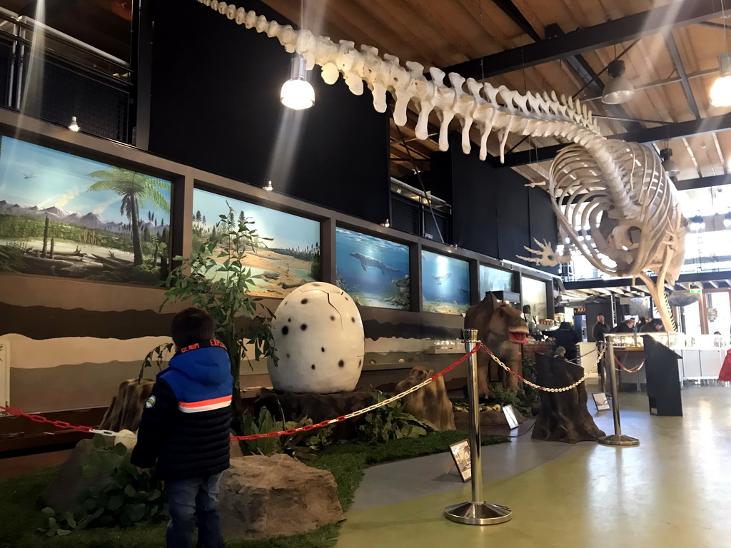 Max with statues of a Maiasaur and a Dinosaur egg, and the skeleton of Casper the Sperm Whale at the Lower Floor of the Museum Building of the Oertijdmuseum