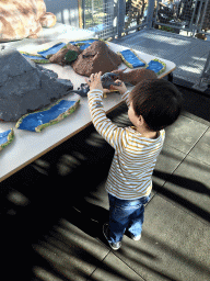 Max playing with dinosaur toys at the Middle Floor of the Dinohal building of the Oertijdmuseum