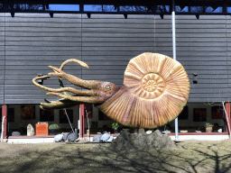 Guineafowls and a statue of an Ammonite in front of the Museum building in the Garden of the Oertijdmuseum