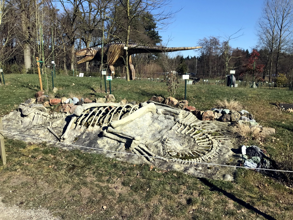 Skeleton of a Dinosaur and a statue of a Giganotosaurus in the Garden of the Oertijdmuseum