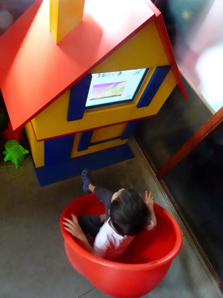 Max looking at a television screen in the hallway from the Dinohal building to the Museum building of the Oertijdmuseum