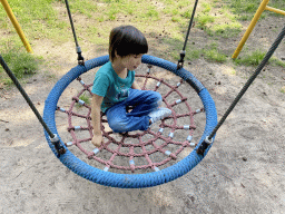 Max on a swing at the playground in the Oertijdwoud forest of the Oertijdmuseum