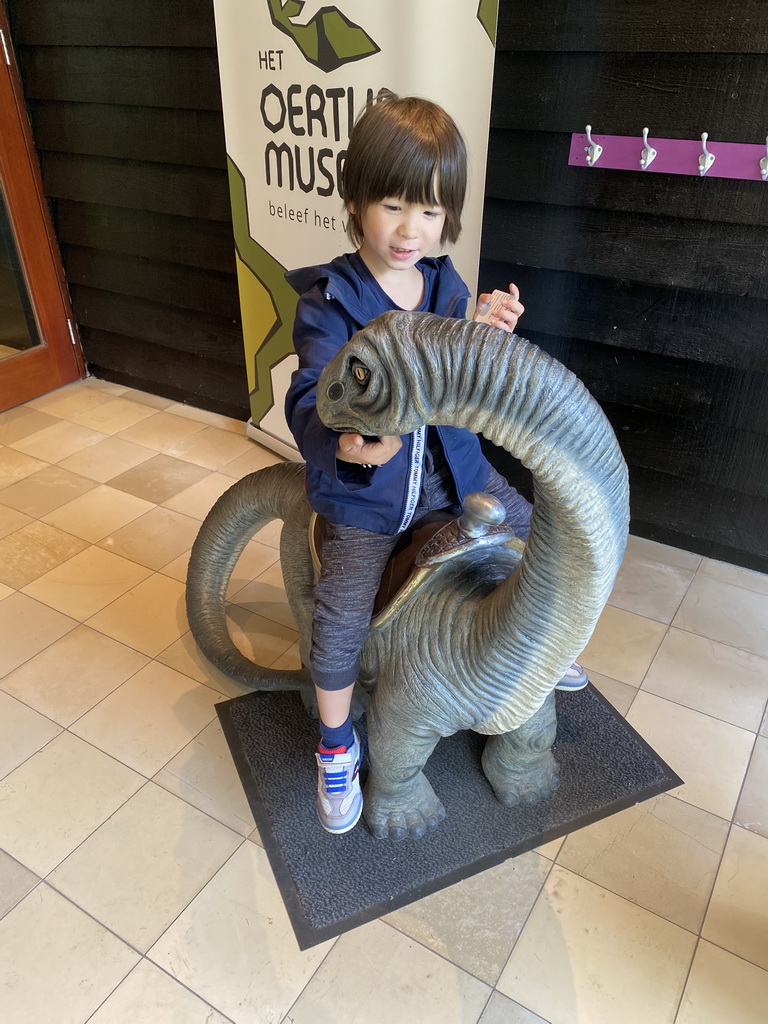 Max on a Diplodocus statue at the entrance to the Oertijdmuseum