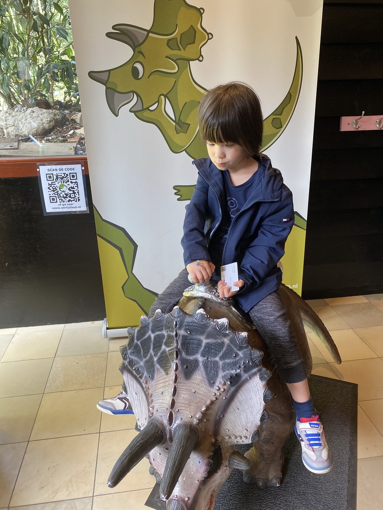 Max on a Triceratops statue at the entrance to the Oertijdmuseum