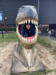 Max in a statue of the head of a Dinosaur at the playground in the Garden of the Oertijdmuseum