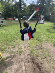 Max on a swing at the playground in the Oertijdwoud forest of the Oertijdmuseum