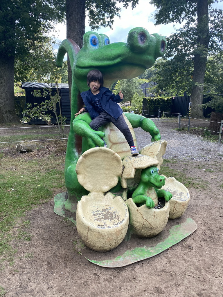 Max on a statue of a Crocodile with eggs at the playground in the Oertijdwoud forest of the Oertijdmuseum