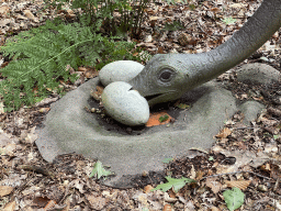 Statue of an Ornithomimus eating eggs in the Oertijdwoud forest of the Oertijdmuseum
