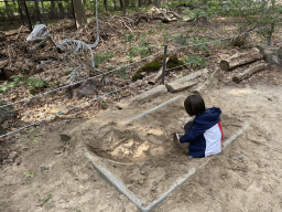 Deinonychus skeleton and Max with brushes at the dinosaur excavation sandbox at the Oertijdwoud forest of the Oertijdmuseum