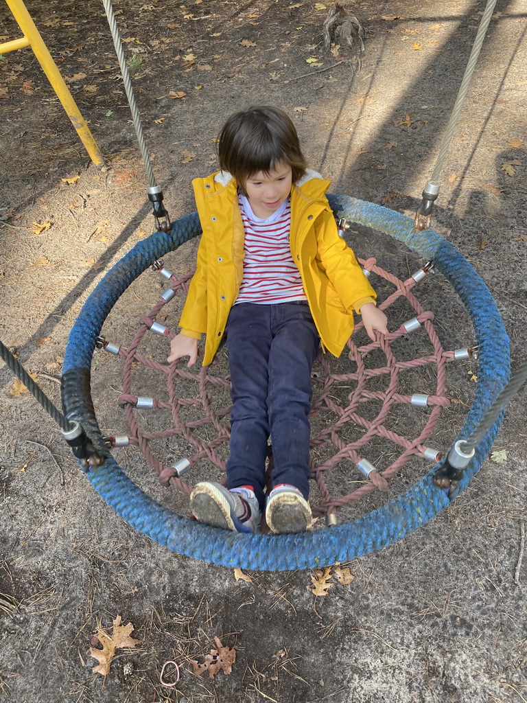 Max on the swing at the playground in the Oertijdwoud forest of the Oertijdmuseum