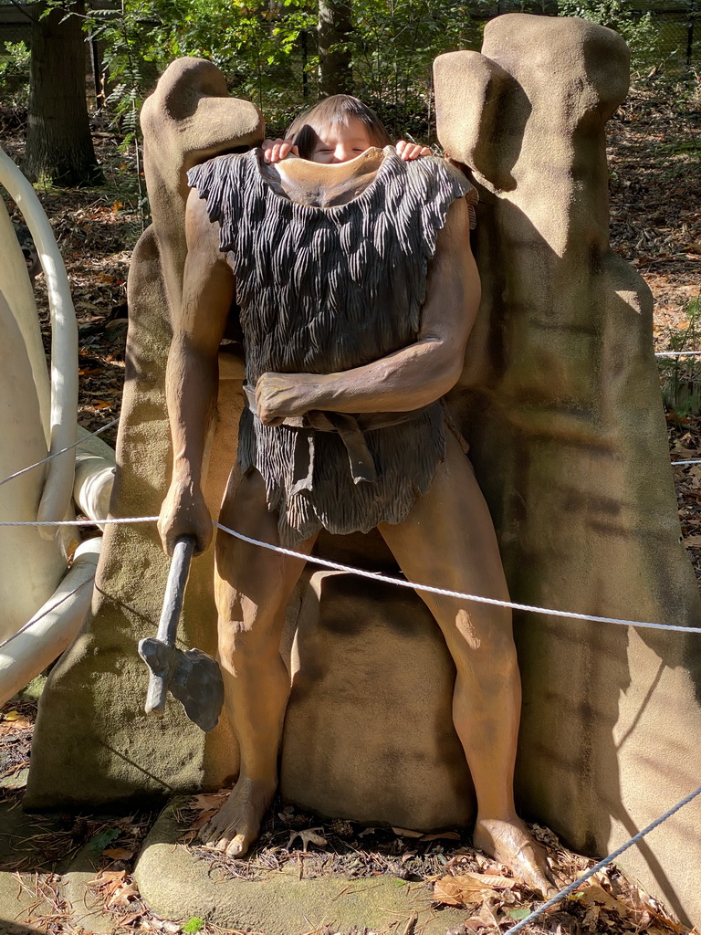 Max with a statue of a caveman in the Oertijdwoud forest of the Oertijdmuseum