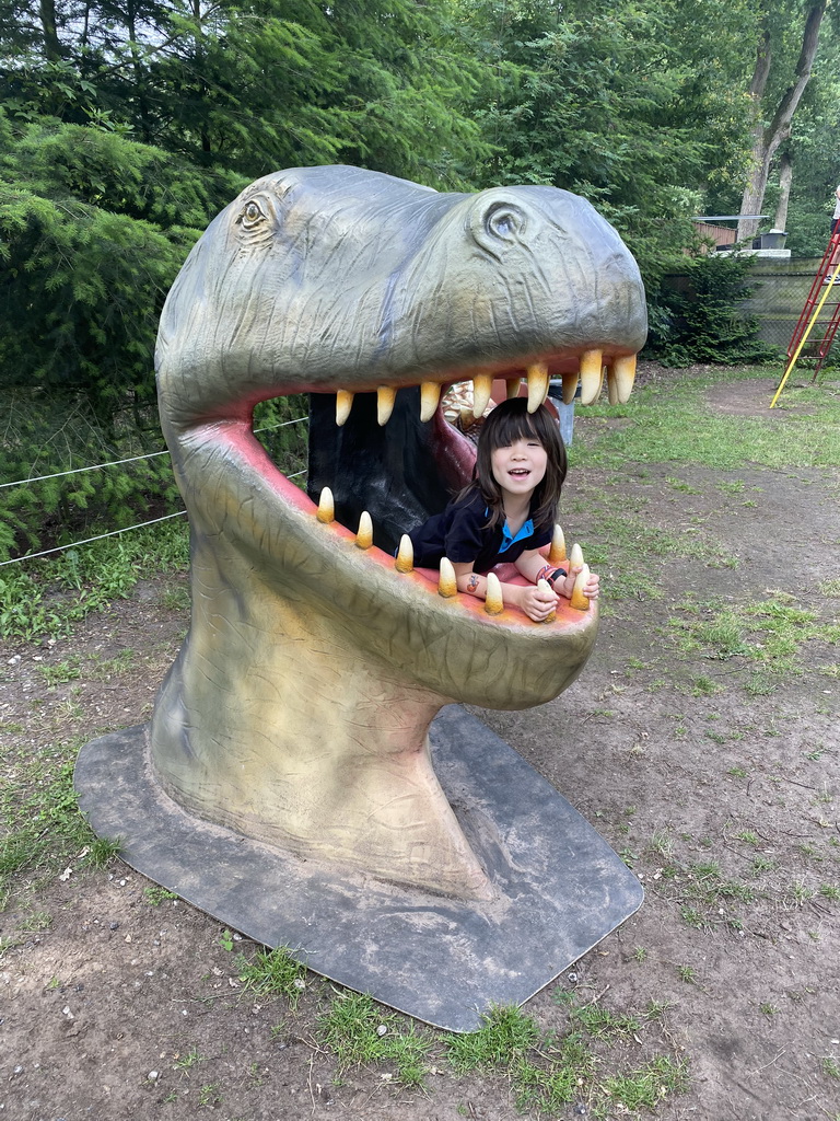 Max in a statue of the head of a Dinosaur at the playground in the Oertijdwoud forest of the Oertijdmuseum