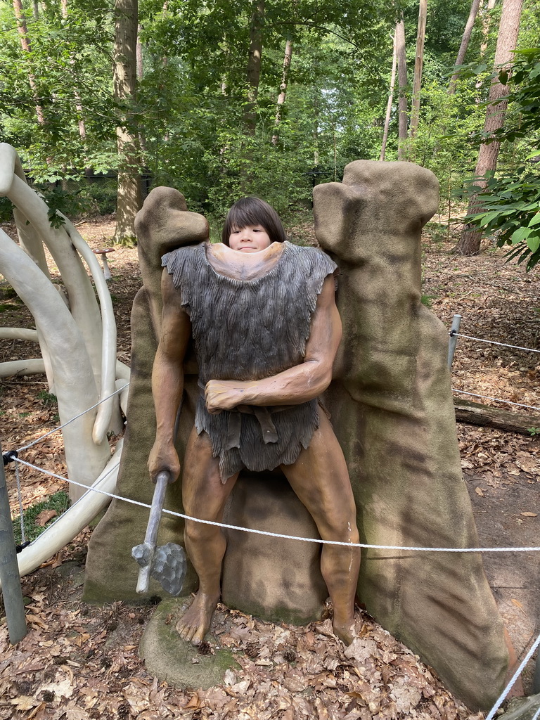 Max with a statue of a caveman in the Oertijdwoud forest of the Oertijdmuseum