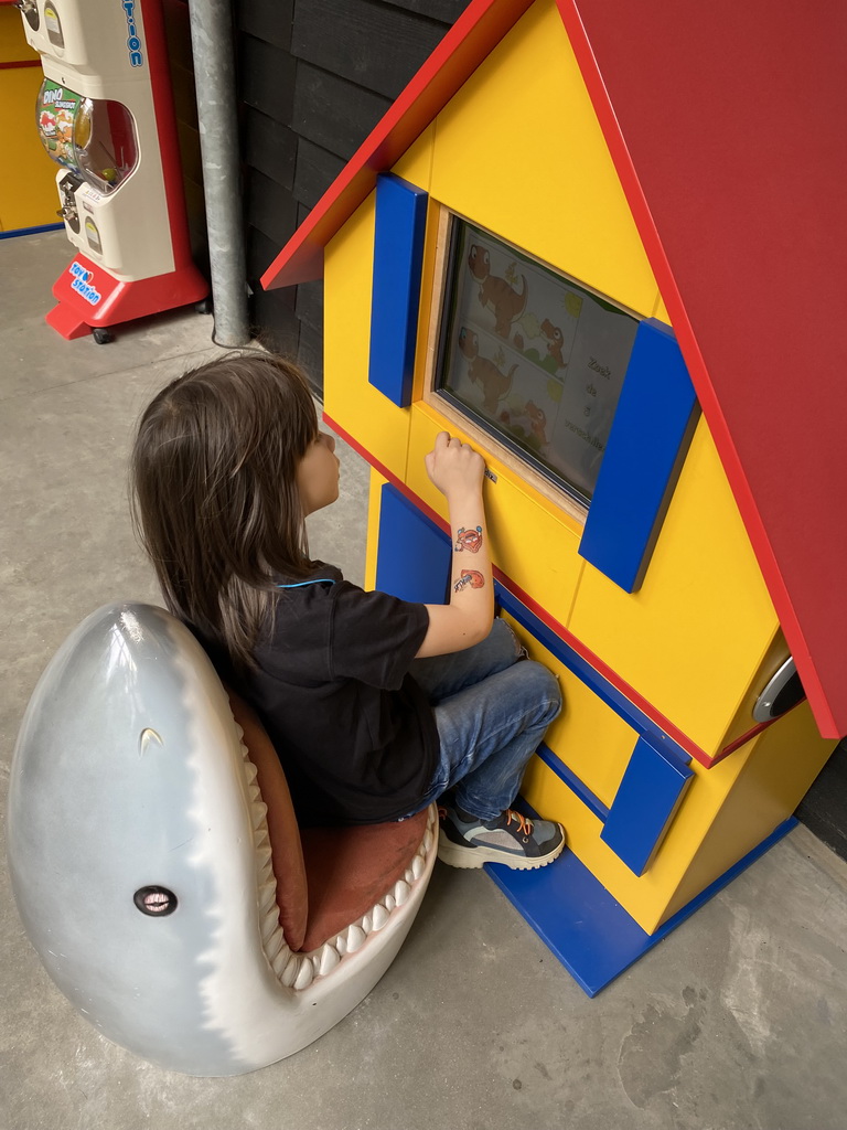 Max looking at a television screen in the hallway from the Dinohal building to the Museum building of the Oertijdmuseum