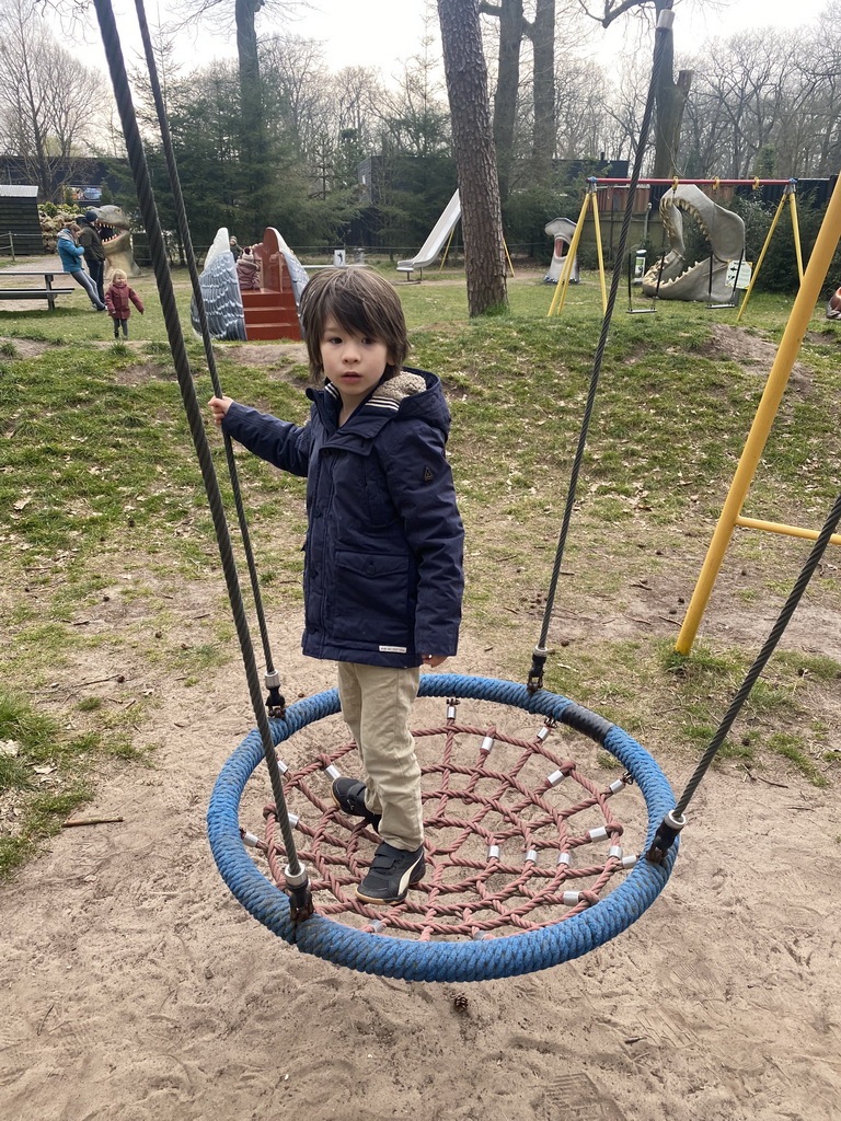 Max on a swing at the playground in the Oertijdwoud forest of the Oertijdmuseum