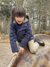 Max on a Maiasaura statue in the Oertijdwoud forest of the Oertijdmuseum
