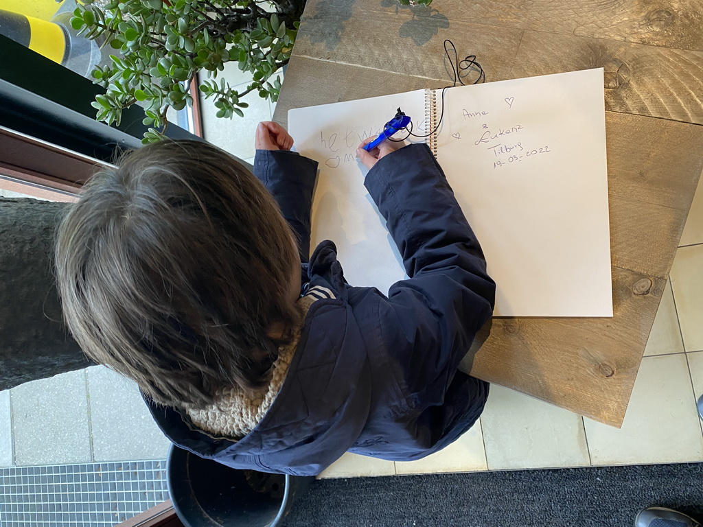 Max writing a message in the guestbook at the Lower Floor at the Museum Building of the Oertijdmuseum